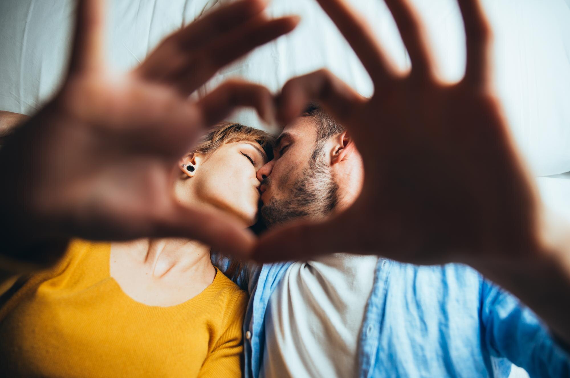 пара показывает сердце пальцами